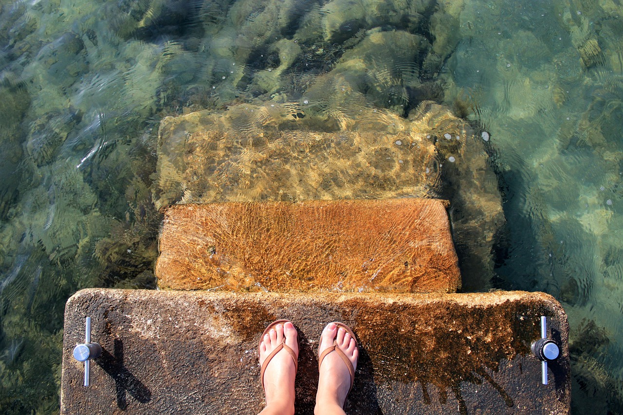 sea water feet sandals flip flops waves crystal clear ocean step clear lake stones nature water surface transparent sea bay stairs level stair step step by step uncertain step forward step into the unknown