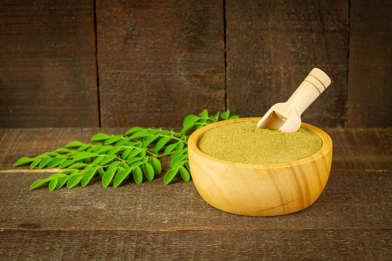 moringa powder leaves moringa oleifera super food healthy vitamins nature herbal supplement organic wooden bowl rustic closeup